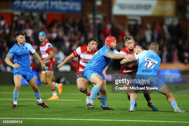 Jack Reeves of Gloucester Rugby is tackled by Mat Gilbert and Lewis Holsey of Worcester Warriors during the Premiership Rugby Cup match between...