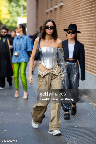 Guest wears unbuttoned beige pants, silver off shoulder top with asymmetric glove outside Fendi during the Milan Fashion Week - Womenswear...