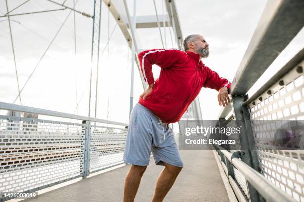 senior sporty man having back pain - sportswear man stock pictures, royalty-free photos & images