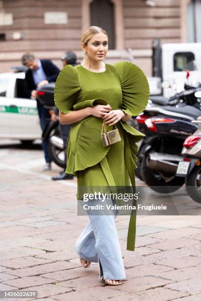 Tatyana Kodzayeva is seen wearing a sculptured green dress over denim pants at Alberta Ferretti show during the Milan Fashion Week - Womenswear...