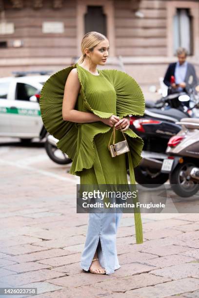 Tatyana Kodzayeva is seen wearing a sculptured green dress over denim pants at Alberta Ferretti show during the Milan Fashion Week - Womenswear...