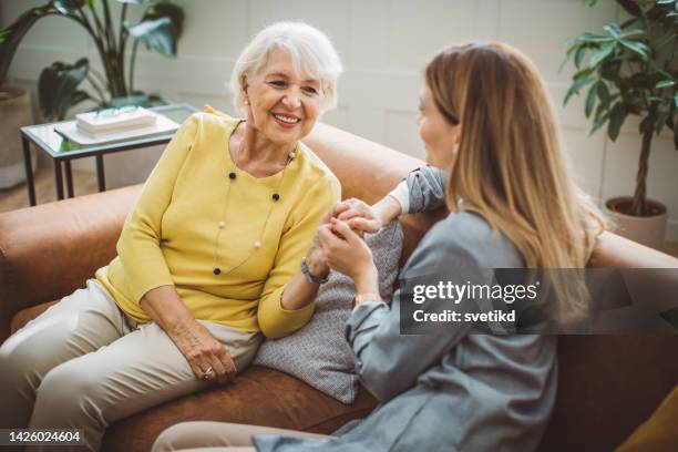 senior woman talking with daughter - adult children with parents stockfoto's en -beelden