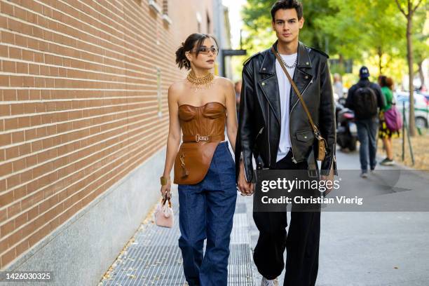 Couple Karina Nigay wears brown off shoulder top, golden necklace, denim jeans, rose bag, sunglasses wears outside Fendi during the Milan Fashion...