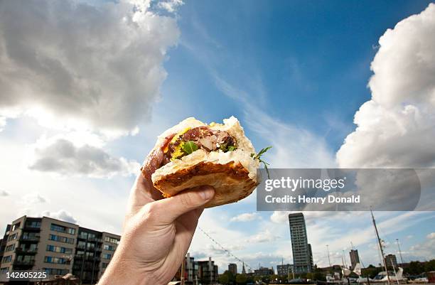 hand holding burger - hand holding burger stock pictures, royalty-free photos & images