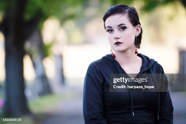 portrait of a teenager with black hair and a nose ring. - young goth girls stock-fotos und bilder