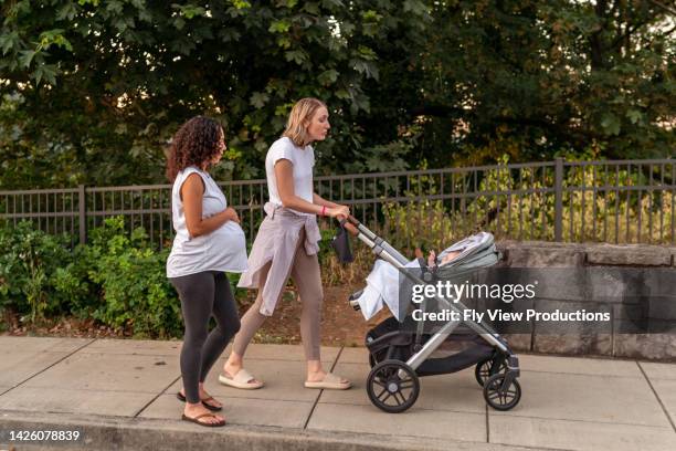 junge mütter gehen gemeinsam in der natur spazieren - baby stroller stock-fotos und bilder