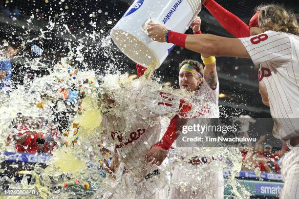 Matt Vierling of the Philadelphia Phillies is doused by teammates Bryson Stott and Alec Bohm after hitting a walk off single to defeat the Toronto...