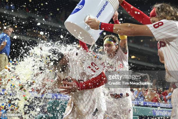 Matt Vierling of the Philadelphia Phillies is doused by teammates Bryson Stott and Alec Bohm after hitting a walk off single to defeat the Toronto...