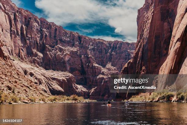 scenic view of lake and red cliffs, paddlers - phoenix stock pictures, royalty-free photos & images