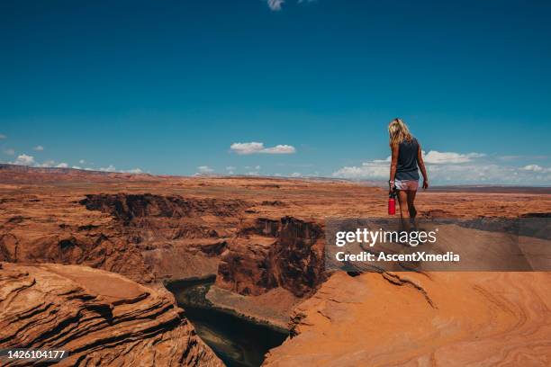 woman walks along canyon ridge above river - phoenix arizona stock pictures, royalty-free photos & images