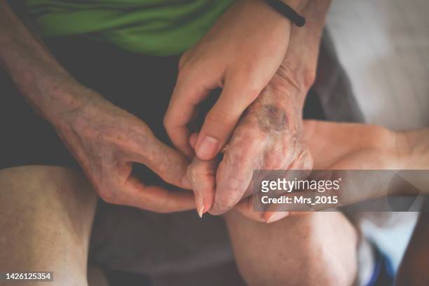 close-up of a boy holding his grandfather's hand - generation gap stock pictures, royalty-free photos & images