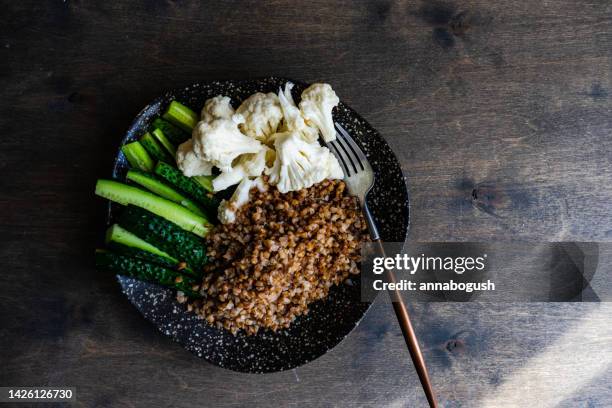 overhead view of a bowl of buckwheat with raw cucumber and cauliflower - buckwheat fotografías e imágenes de stock