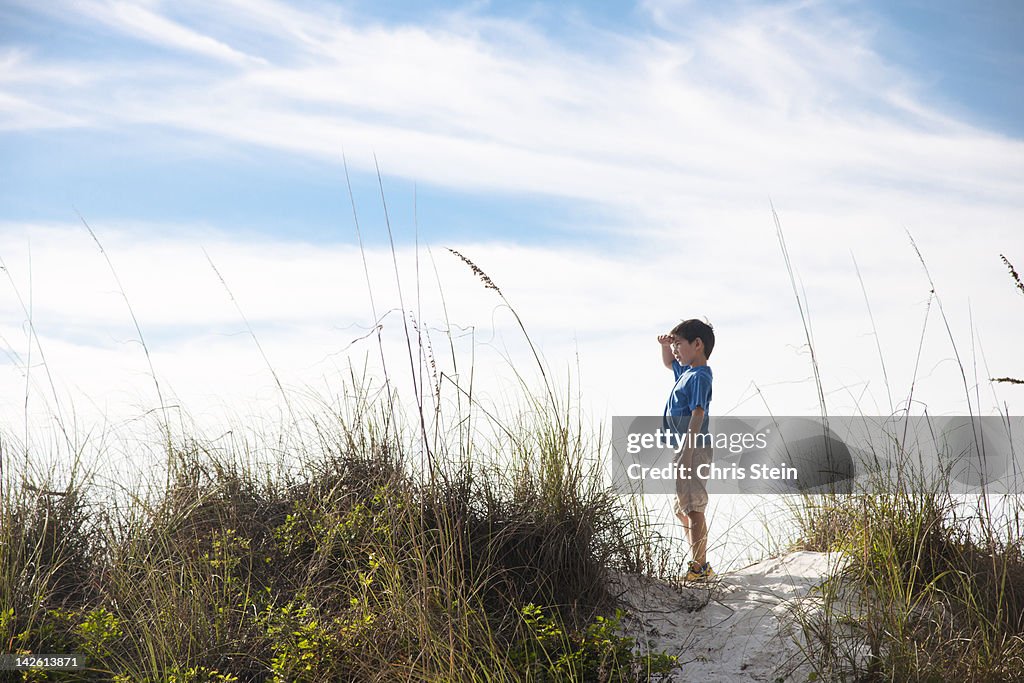 Young Boy standing on top of a Beach Dune