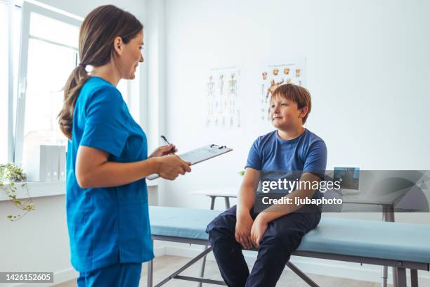 teenage boy and doctor have consultation in hospital room - er visit stock pictures, royalty-free photos & images