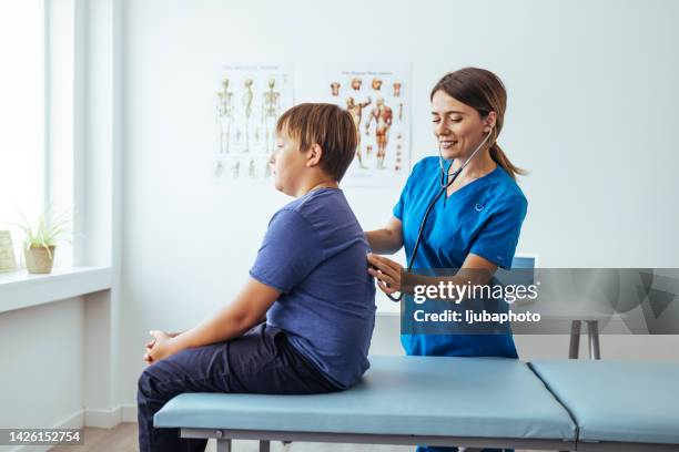 female healthcare nurse checks teen patient's lungs - assistant professor stock pictures, royalty-free photos & images