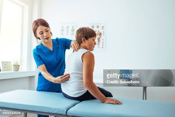 doctor examining childs posture - scoliosis stock pictures, royalty-free photos & images
