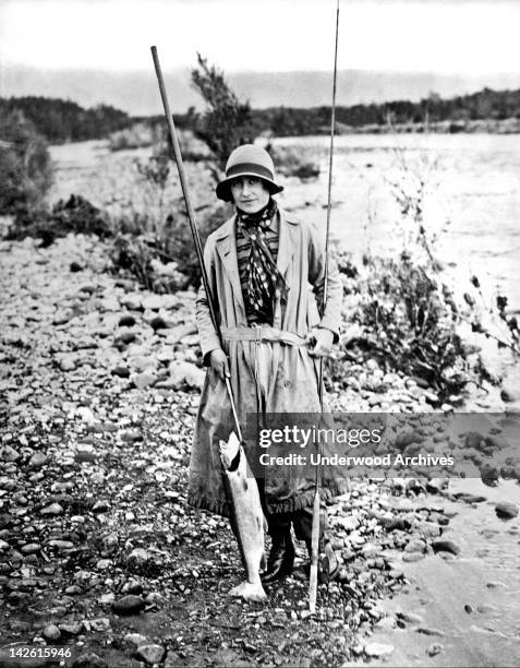 The Duchess of York who is making a tour of British Possessions, with a 7 pound trout she caught, Tokaanu, New Zealand, April 1927. She later became...