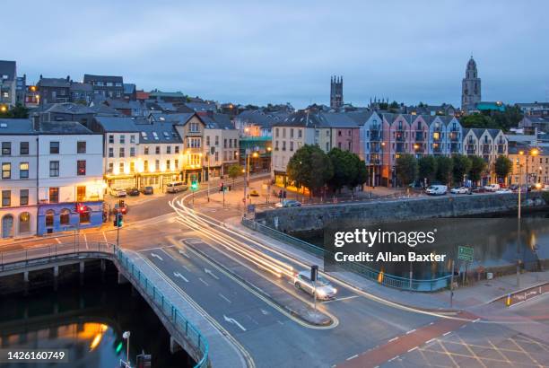 aerial view of the skyline of cork city illuminated at dusk - cork city stock-fotos und bilder