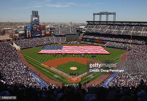 The American Flag is displayed on the field as the national anthem is observed prior to the game between the San Francisco Giants and the Colorado...