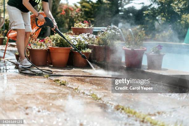 unrecognizable person cleaning the poolside with high pressure water cleaning - sidewalk sweeper imagens e fotografias de stock