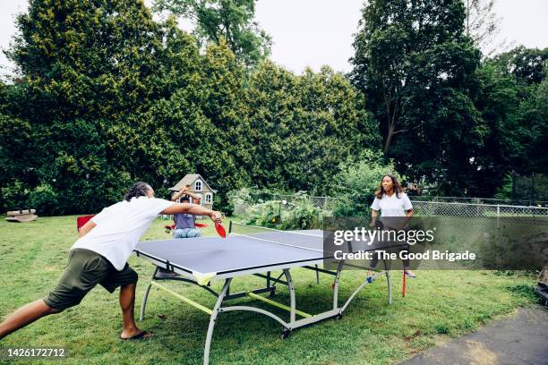 father and daughter playing ping pong in back yard - men's table tennis stock pictures, royalty-free photos & images