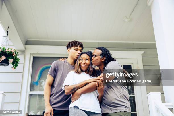 portrait of father and adult offspring on front porch - kiss sisters foto e immagini stock