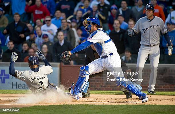 Nyjer Morgan of the Milwaukee Brewers scores on a sacrifice fly hit by teammate Aramis Ramirez as catcher Geovany Soto of the Chicago Cubs tries to...