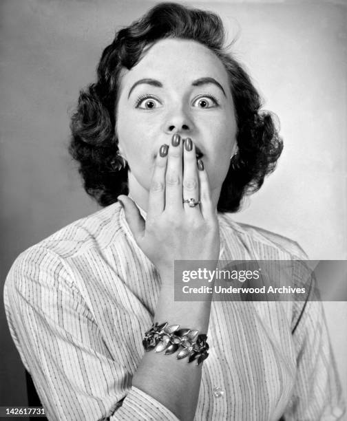 Woman has her hand over her mouth trying to stop her hiccups, Detroit, Michigan, September 10, 1957.