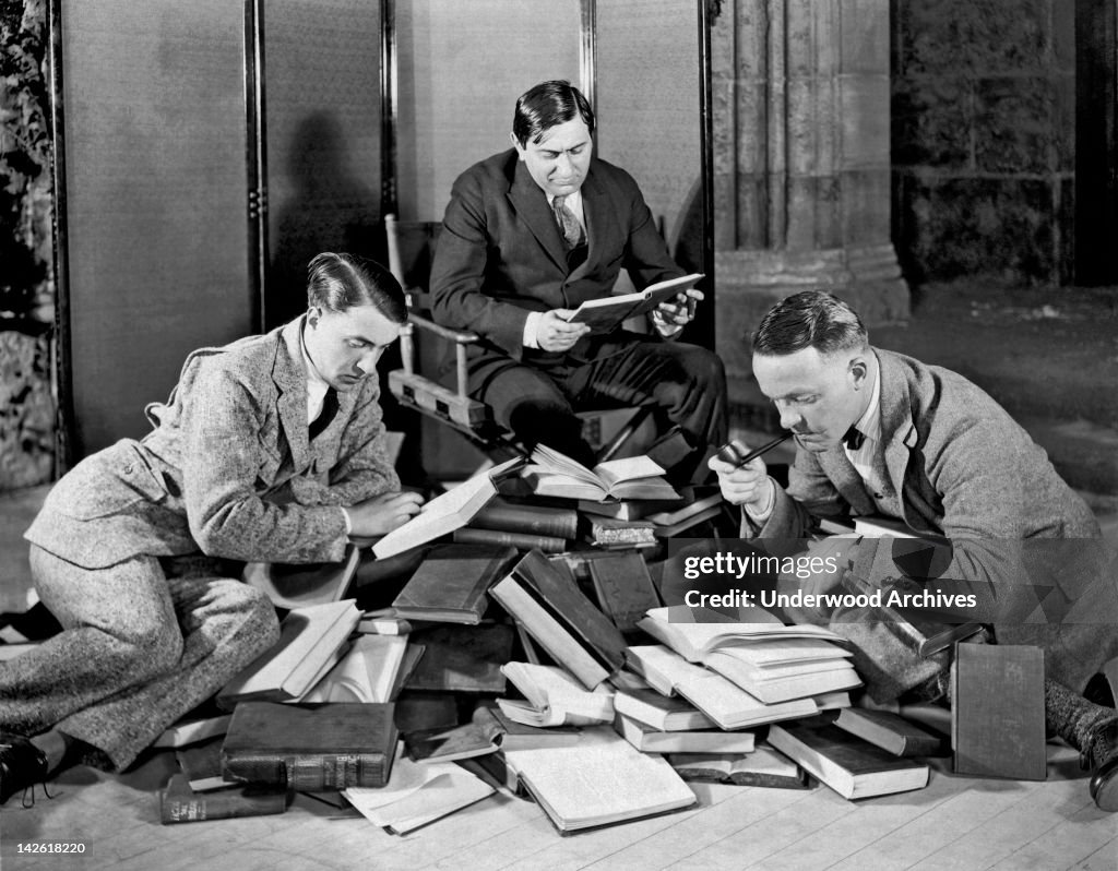 Three Men Searching Books