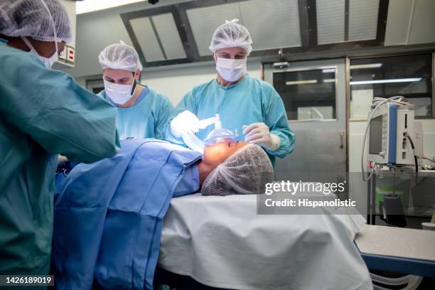 nurses and anesthetist preparing a female patient in the or - anesthesia stock pictures, royalty-free photos & images