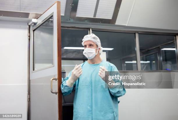 lead surgeon walking into the or ready for the surgery with his biosecurity elements - doctor scrubs stock pictures, royalty-free photos & images