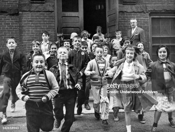 Students rushing out of the school building for summer vacation after the last day of classes, June 1954.