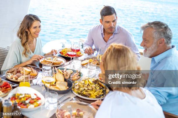 family having lunch on deck - family trip in laws stock pictures, royalty-free photos & images