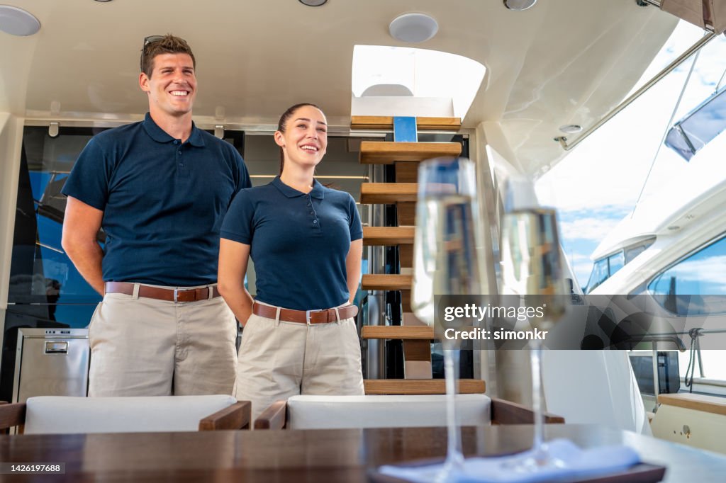 Skipper and stewardess standing in yacht