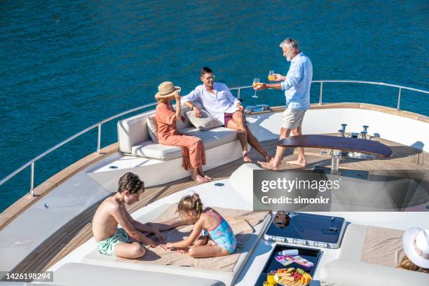 familia disfrutando en yate - embarcación de recreo fotografías e imágenes de stock