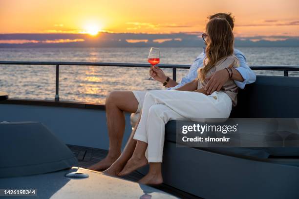 couple sitting on yacht - luxe jacht stockfoto's en -beelden