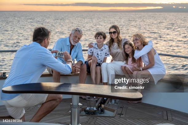 family taking photograph on yacht - wealthy family stock pictures, royalty-free photos & images