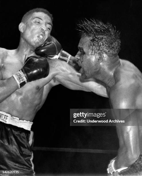 Sugar Ray Robinson throws a hard right to the jaw of middleweight champion Randy Turpin in the tenth round of their title bout at the Polo Grounds,...