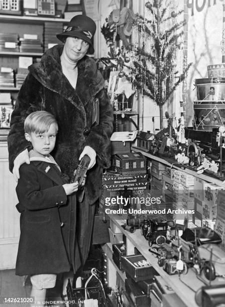 Freddie Hicks, son of Alien Property Custodian Hicks, gets an pre-season tour of Toyland with his mother, Washington DC, December 5, 1925.