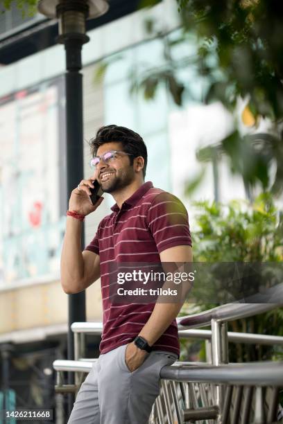 man using mobile phone outdoors in city - phone leaning stock pictures, royalty-free photos & images