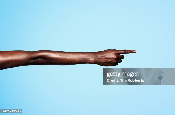 woman pointing with coloured background - wijzen handgebaar stockfoto's en -beelden