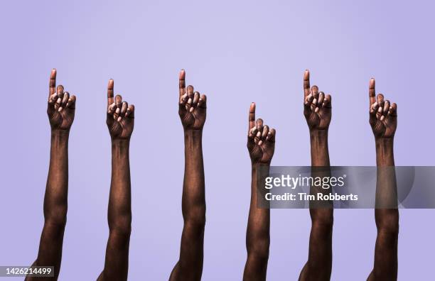 arms being held up with extended finger - human finger 個照片及圖片檔