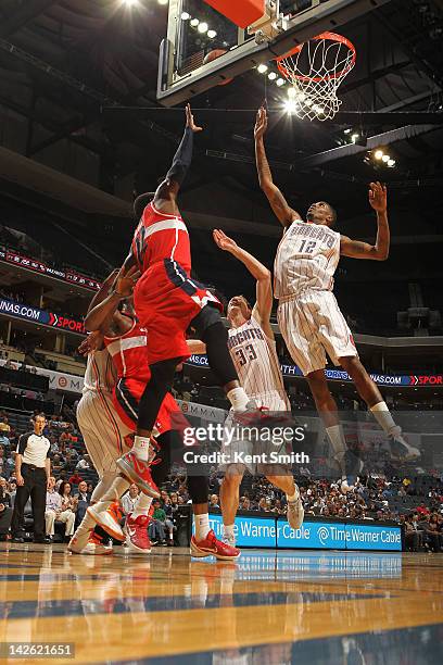 Tyrus Thomas and Matt Carroll of the Charlotte Bobcats go for the rebound against Shelvin Mack of the Washington Wizards at the Time Warner Cable...