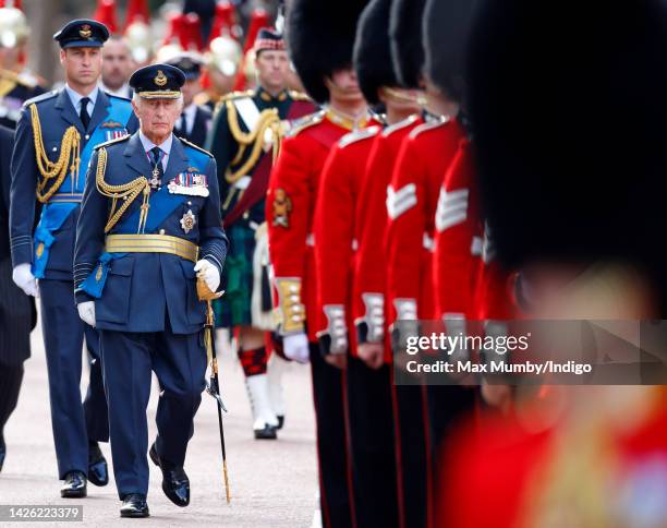 Prince William, Prince of Wales and King Charles III walk behind Queen Elizabeth II's coffin as it is transported on a gun carriage from Buckingham...