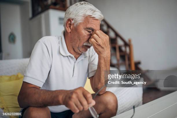 uomo anziano preoccupato a casa - bill legislation foto e immagini stock
