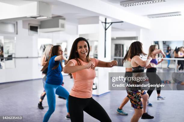 mujer sonriendo durante los movimientos de la clase de baile de zumba - gym stepper fotografías e imágenes de stock