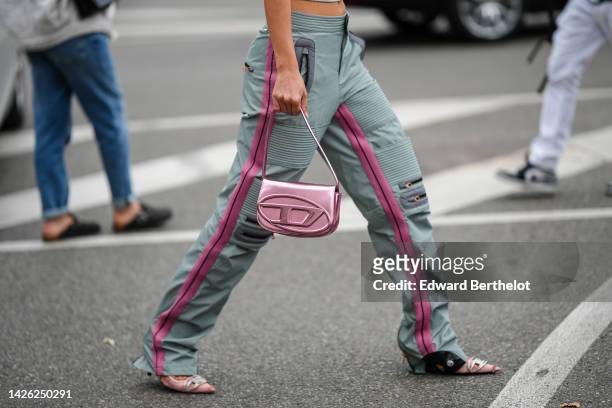 Guest wears pale gray embossed striped pattern leather / zipper knees / pink straps large pants, a gold shiny leather Diesel handbag from Diesel,...