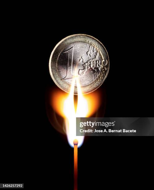 flame of a match that ignites the natural gas that is burning a euro coin - recessed lighting 個照片及圖片檔