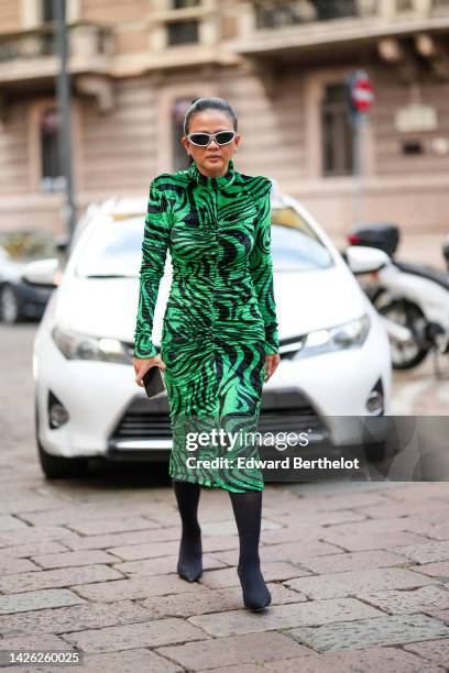Guest wears silver sunglasses, a green and black zebra print pattern shoulder-off / long sleeves / long velvet tube dress, black nylon pointed /...