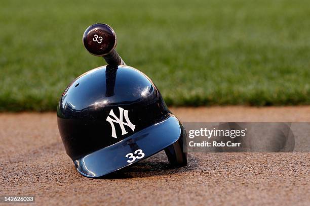 The batting helmet and bat of Nick Swisher of the New York Yankees sit on the ground before the start of the Yankees game against the Baltimore...